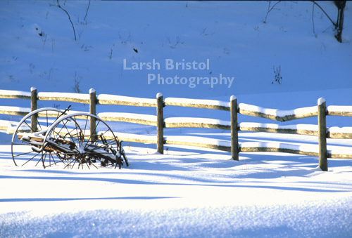 Snow Covered Fence and Wagon Wheeled Trailer